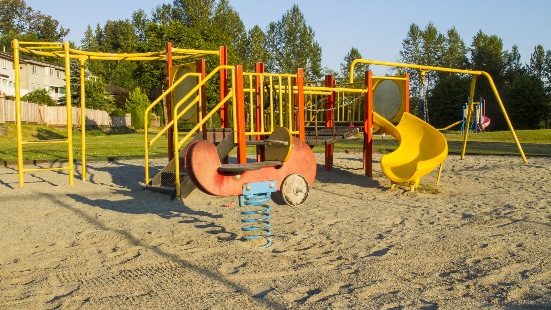 A short playground with a tire swing next to it.